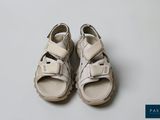 a pair of white sandals sitting on top of a white surface