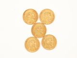 quatre pièces d'or sont disposées de manière à former le visage d'un homme