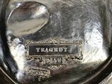 a silver plate with a spoon in it on a table