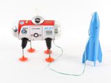 a small toy robot with a rocket on the ground