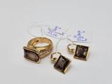 two rings and a pair of earrings are on a white surface