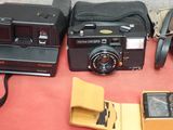 many different types of cameras on a red table