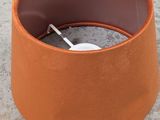 an orange lamp shade with a white button on it