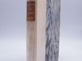 an old book sitting on top of a white table next to a white wall