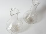 pair of clear glass vases sitting on a white surface
