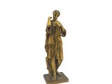 une statue en bronze représentant une femme tenant un téléphone portable