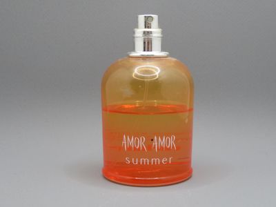 un flacon de parfum orange posé sur une table blanche