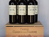 quatre bouteilles de vin rouge dans un coffret en bois posé sur une table