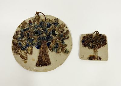 two pieces of pottery with a tree on them