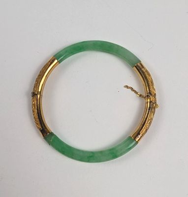 une image représentant un bracelet vert rehaussé de touches dorées sur un fond blanc