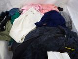 a pile of clothes in a white bag on the floor