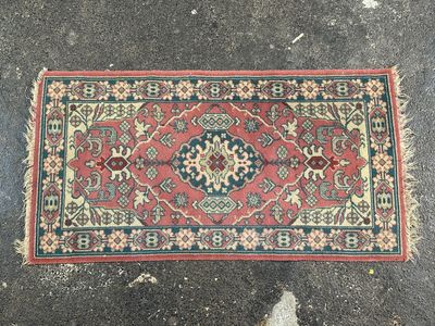 un gros plan d'un tapis posé au sol, avec une personne debout à côté