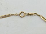 a close up of a gold bracelet on a white surface
