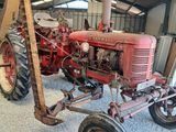 un tracteur rouge garé à l'intérieur d'un bâtiment