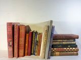 several books are stacked on top of each other on a white surface