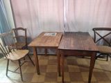 two wooden chairs and a table in a room