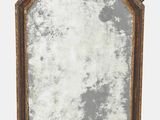 un vieux miroir avec un cadre en bois et un fond blanc