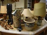 a table with a lamp, a vase, a lamp, and other items on it