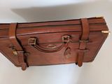 a brown piece of luggage hanging on the wall