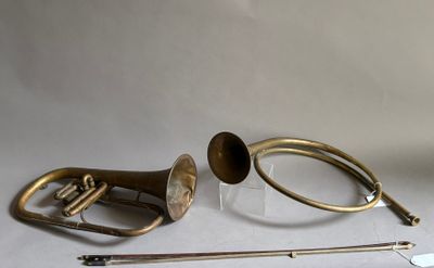 une trompette, un cor et un bâton posés sur une table