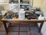many plates and bowls on a table in the kitchen