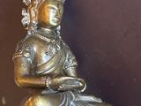 une statue en argent représentant une femme tenant un miroir
