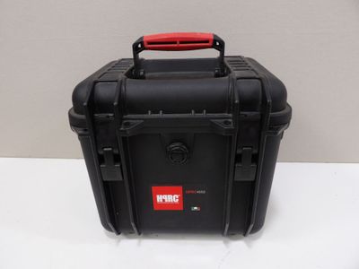 a close up of a black case with a red handle on a table