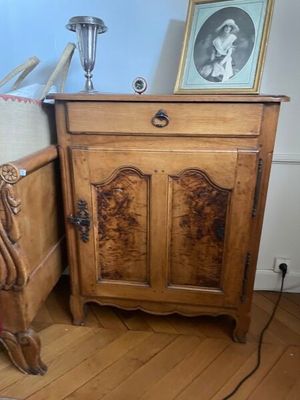 une armoire en bois posée à côté d'un lit dans une chambre