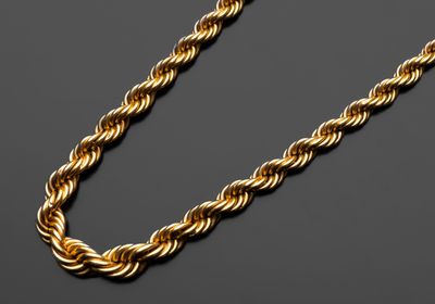 un collier à maillons dorés sur fond noir