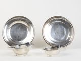 pair of silverplated dishes on stands on a white surface