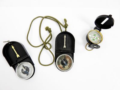 three different types of compasses on a white surface