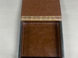 a brown box with a silver lid on a white surface