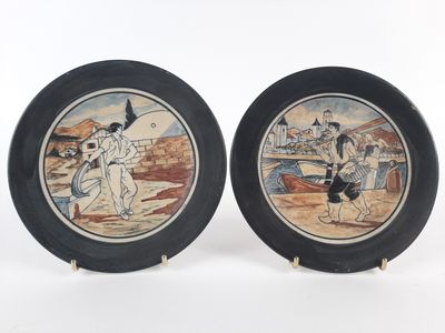 pair of decorative plates depicting a man and a woman on a beach