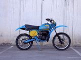 a blue dirt bike parked in a parking lot