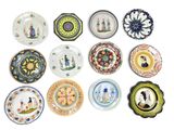 de nombreuses assiettes aux motifs variés, disposées sur un fond blanc