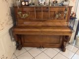 un piano dans un coin de la pièce, sur lequel est posée une horloge