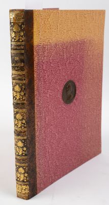 an old book sitting on top of a white table next to a button