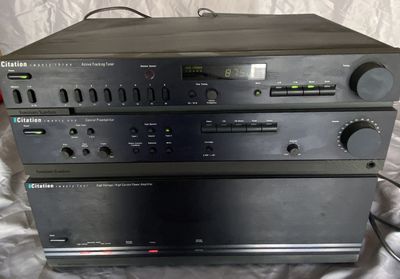 deux chaînes hi-fi sont empilées l'une sur l'autre sur un lit