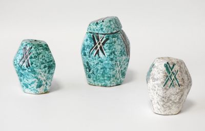 trois vases en céramique décorés, posés sur une surface blanche