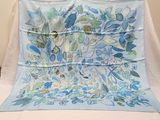 a blue and green floral design on a blue and white blanket