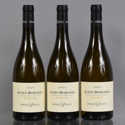 trois bouteilles de vin posées sur une table l'une à côté de l'autre
