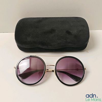 des lunettes de soleil et leur étui posés sur une table à côté d'une paire de lunettes