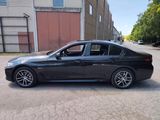 a picture of a black bmw sedan parked in front of a building