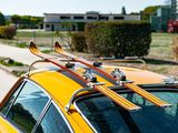a yellow car with skis on top of it