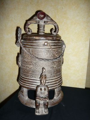 un récipient en métal orné d'une statue de Bouddha
