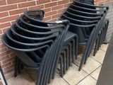 a lot of chairs that are lined up against a brick wall