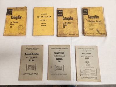 several old manuals are sitting on a table in front of a white table
