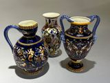 deux vases bleus et dorés posés l'un à côté de l'autre sur une table