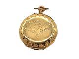 a gold pocket watch with a signature on it