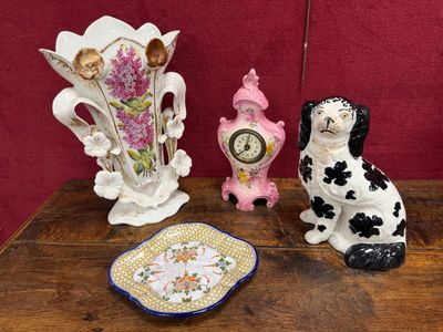 three figurines sitting on a table next to a clock